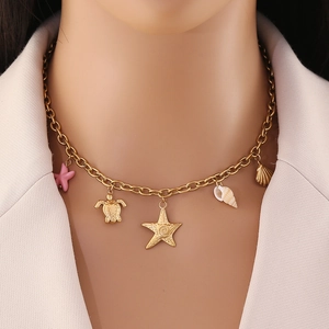 Gold ocean themed necklace featuring starfish and turtle pendants on model