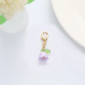 Close-up of light purple lily of the valley flower pendant with golden lobster clasp