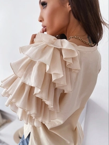 Detail of layered ruffle sleeve design on cream-colored long-sleeve casual top