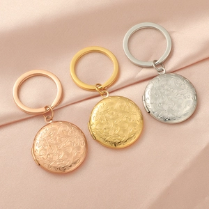 Detailed view of floral embossed locket keychains in gold, rose gold and silver finishes