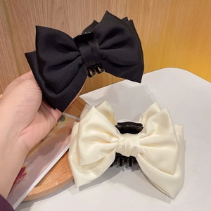 Detail of satin bow hair clips in black and white colors for girls and women