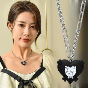 Detail of clover heart necklace with black pendant and mixed chain link design