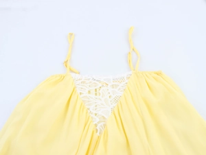 Détail d'une robe d'été en mousseline jaune avec dentelle blanche délicate au décolleté