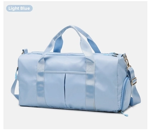 Detail of light blue gym bag featuring wide handles, side pocket and durable nylon fabric