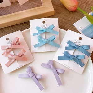 Detail view of handmade satin ribbon bow hair clips in multiple soft pastel colors