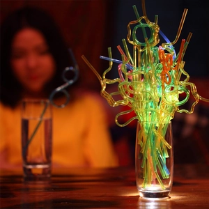 Close-up of colorful PET plastic straws twisted into creative fun shapes in a glass