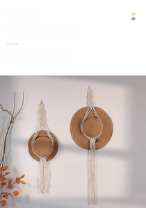 Detail of hand-woven cotton rope hat rack featuring tassels and bohemian wall hanging style