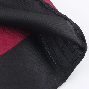 Close-up of paisley wrap dress hem showing high-quality stitching and dark red fabric