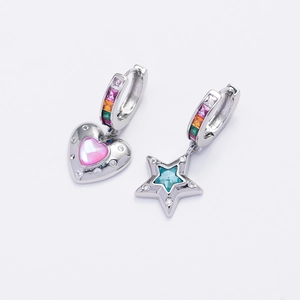 Macro view of asymmetric star and heart earrings with colorful zircon stones in silver