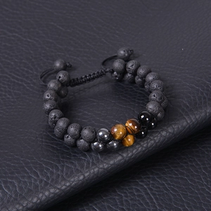 Macro view of adjustable double-row tiger eye and lava stone beaded bracelet on leather