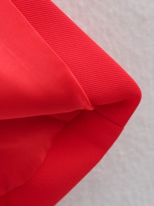 Detailed close-up of red vest fabric showing fine twill texture and smooth inner lining