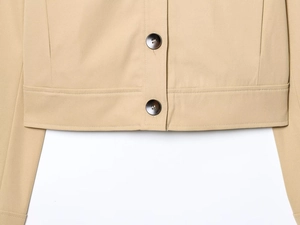 Close-up of khaki twill fabric texture and brown buttons on padded shoulder jacket