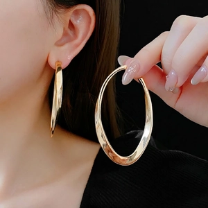 Polished gold large oval hoop earrings for women with minimalist geometric style