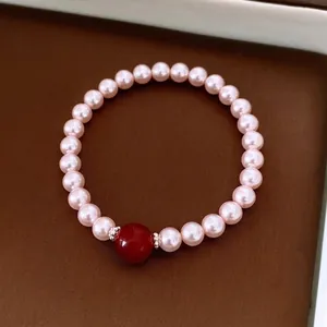 Bracelet élégant avec perles roses et pierre d'agate rouge sur fond de cuir de luxe