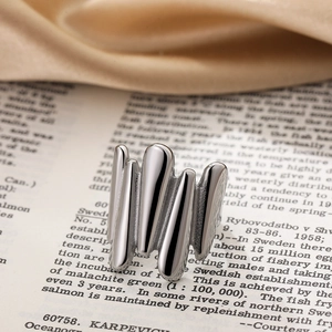 Macro view of silver liquid metal ring with irregular melting texture on vintage book