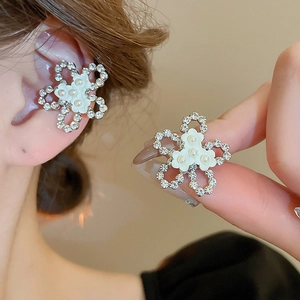 Elegant silver bow earrings with zircon flower petals and white pearls on a model
