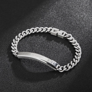 Macro view of silver cuban chain bracelet featuring engraved Roman numeral bar detail