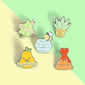 Macro shot of five enamel lapel pins with punny text on a pastel color background