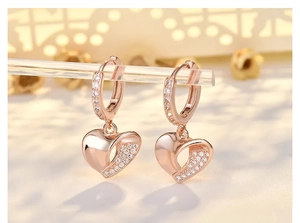 Macro view of rose gold heart earrings featuring white zircon pavé and hollow design