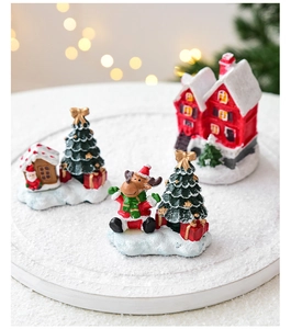 Detailed view of three resin Christmas miniatures including houses and reindeer figurines