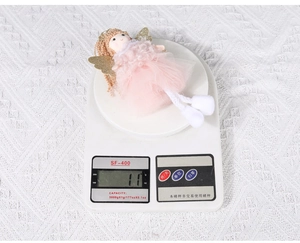 Detail shot showing a 11g lightweight pink handmade angel ornament on a digital scale