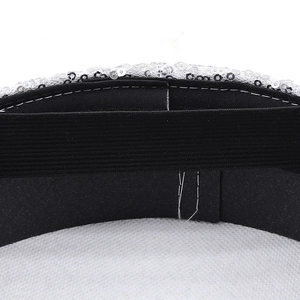 Detail shot of white sequins and black elastic band on the festive bride hat