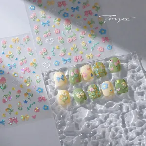 Macro detail of 3D embossed floral nail stickers with tulip and bow patterns