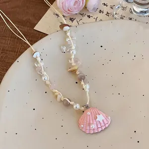 Détail du collier de perles fait main avec pendentif étoile de mer rose et perles
