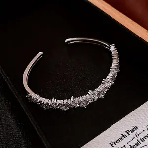 Elegant silver-toned open cuff bangle featuring cubic zirconia pave in a black jewelry box