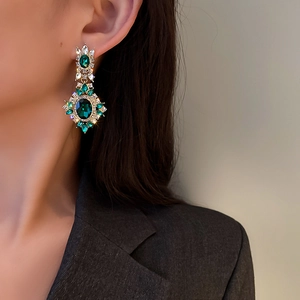Vintage emerald flower earrings with diamonds on model in soft natural lighting