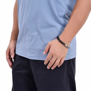 Detail of beaded cross bracelet with matte black and grey marble stones on male wrist
