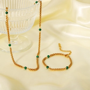 Détail macro du parure chaîne plaqué or 18K avec perles de malachite sur soie