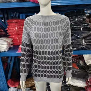 Close-up of gray geometric honeycomb knit pattern on a loose crewneck sweater