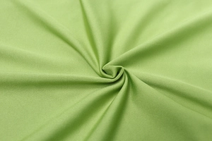Macro shot of grass green ribbed knit fabric showing fine texture and elastic quality