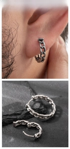 Detail view of retro silver cuban chain earrings displayed on natural grey stone background
