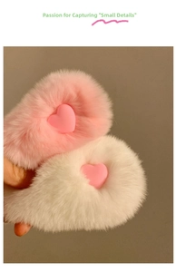Close-up of pink and white plush heart hair clips showing soft faux fur texture