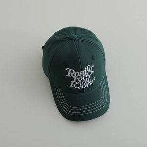 Détail de la casquette en coton vert forêt avec broderie blanche et coutures renforcées