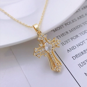 Macro detail of a gold cross pendant necklace featuring sparkling zircon stones