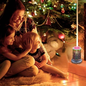 Scented wax warmer with 3D fireworks effect and family celebrating by a Christmas tree