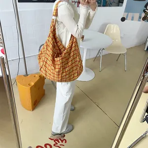 Detail einer großen Hobo-Tasche mit gelb-rot kariertem Stoff im lässigen Retro-Stil