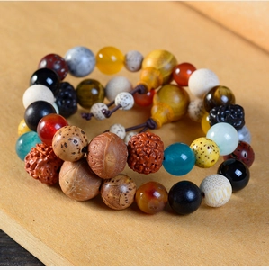 Detailansicht eines traditionellen Bodhi-Armbands mit bunten Steinperlen auf Holz