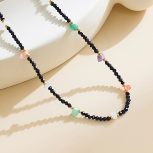 Detail of bohemian necklace with black faceted beads and multi-colored natural stones