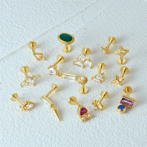 Flat back gold labret studs featuring opal accents and colorful gemstones on white background