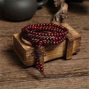 Macro shot of deep red sandalwood prayer beads with traditional Chinese knot on a wooden box