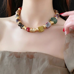 Vintage floral ceramic beaded necklace with gold spiral accents on a female model
