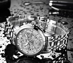 Detail of waterproof stainless steel watch with hollow dial on a dark water-splashed background