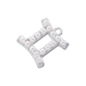 Detail of silver letter H charm with white pearl inlay for DIY jewelry crafting