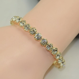 Single row sparkling rhinestone gold-plated open bracelet worn on a female wrist