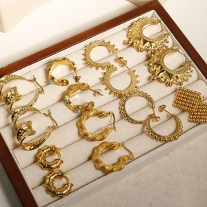 Selection of 18k gold-plated stainless steel geometric earrings on a linen cushion