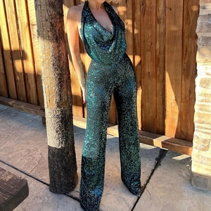 Détail d'une combinaison à paillettes vert foncé avec dos nu et col licou à la lumière